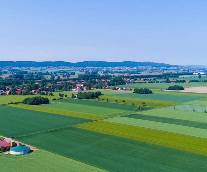 Landschaft mit grünen Feldern, Biogasanalge und Windrad