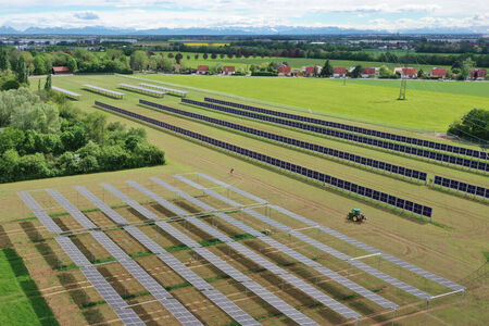 Photovoltaik-Anlage auf einem Feld mit Traktor