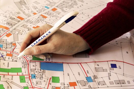 Hand mit Stift auf Stadtplan